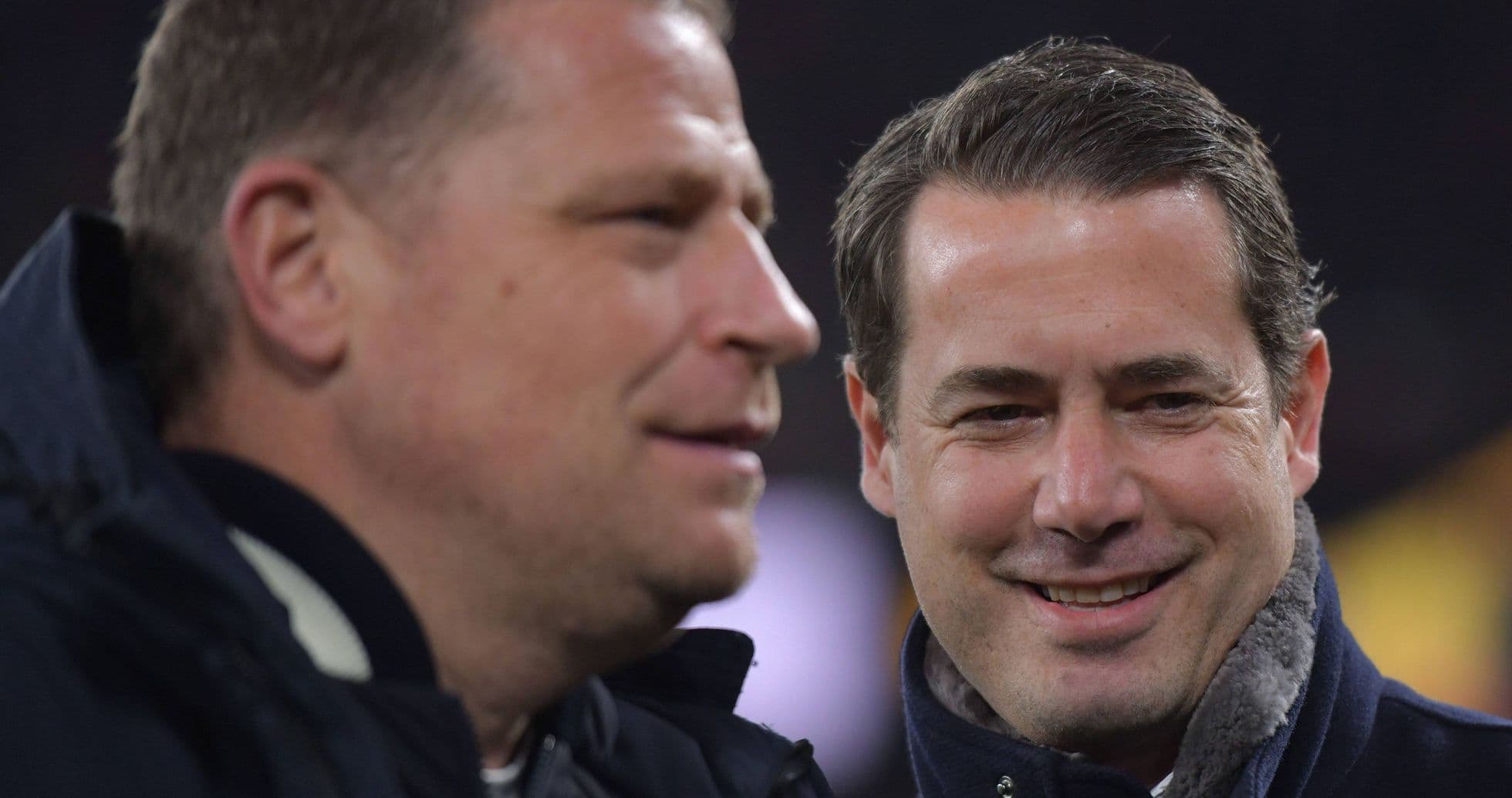 Two men conversing at a sports event
