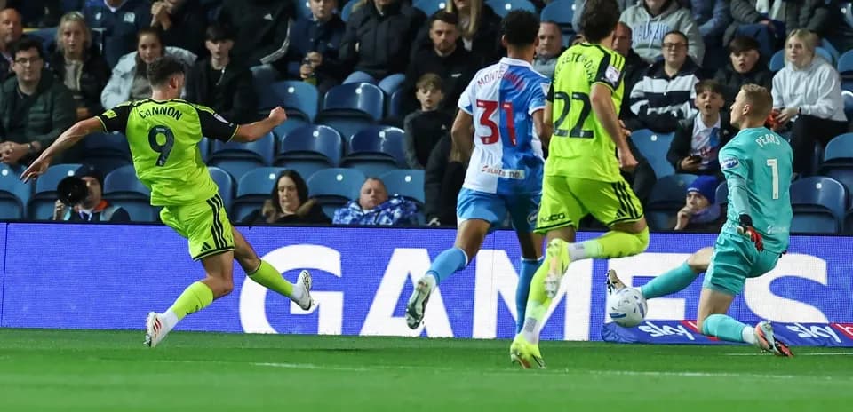 Player shooting on goal while goalkeeper attempts save