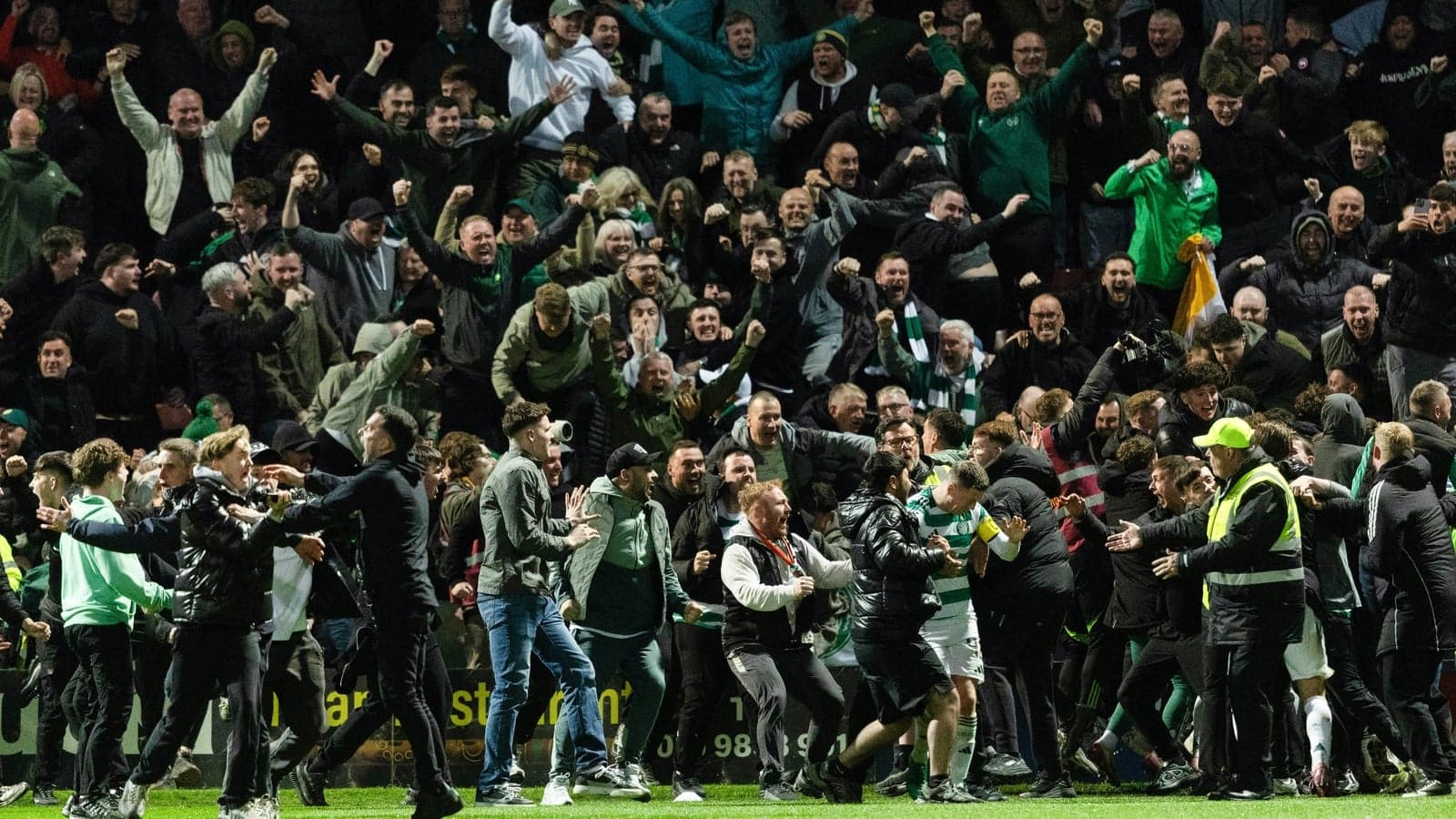 Fans celebrating with players on the pitch