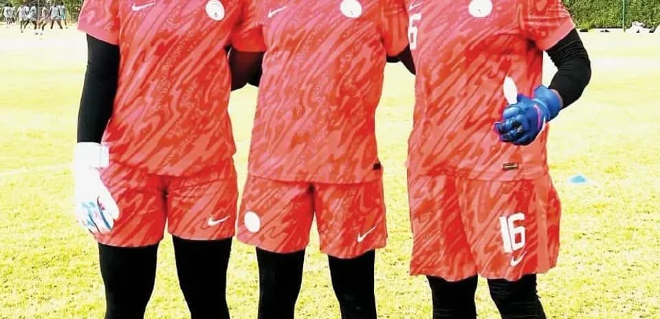 Three female football players posing in training kit
