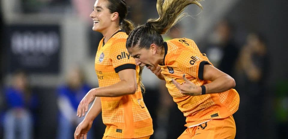 Two Houston Dash players celebrating a goal