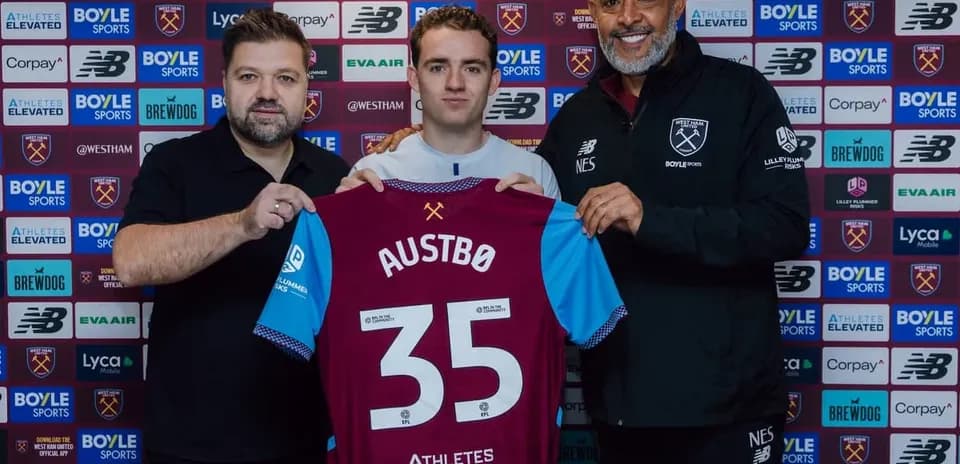 Player holding jersey with 'AUSTBØ' during signing ceremony
