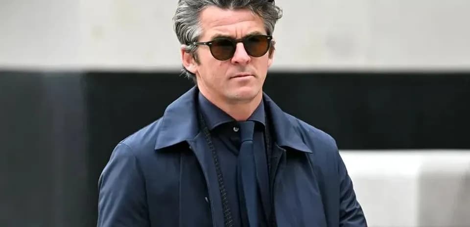 Man in sunglasses walking outdoors in stylish attire