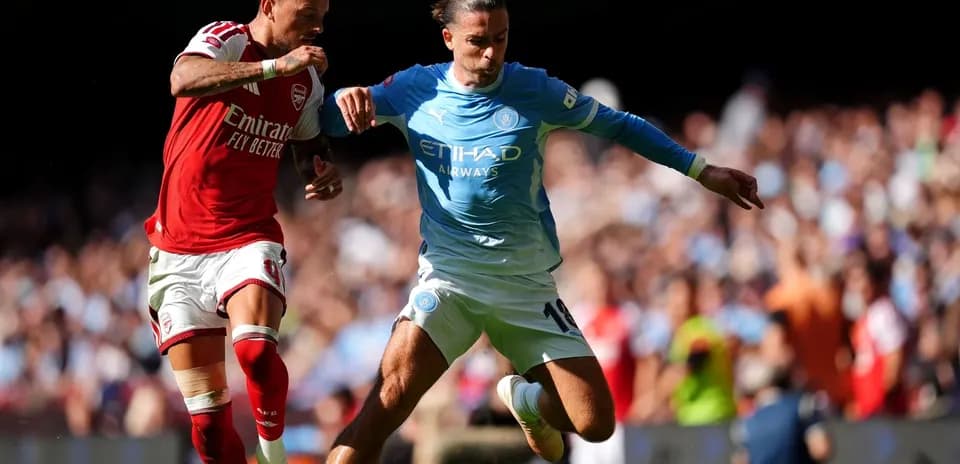 Arsenal and Manchester City players competing for the ball