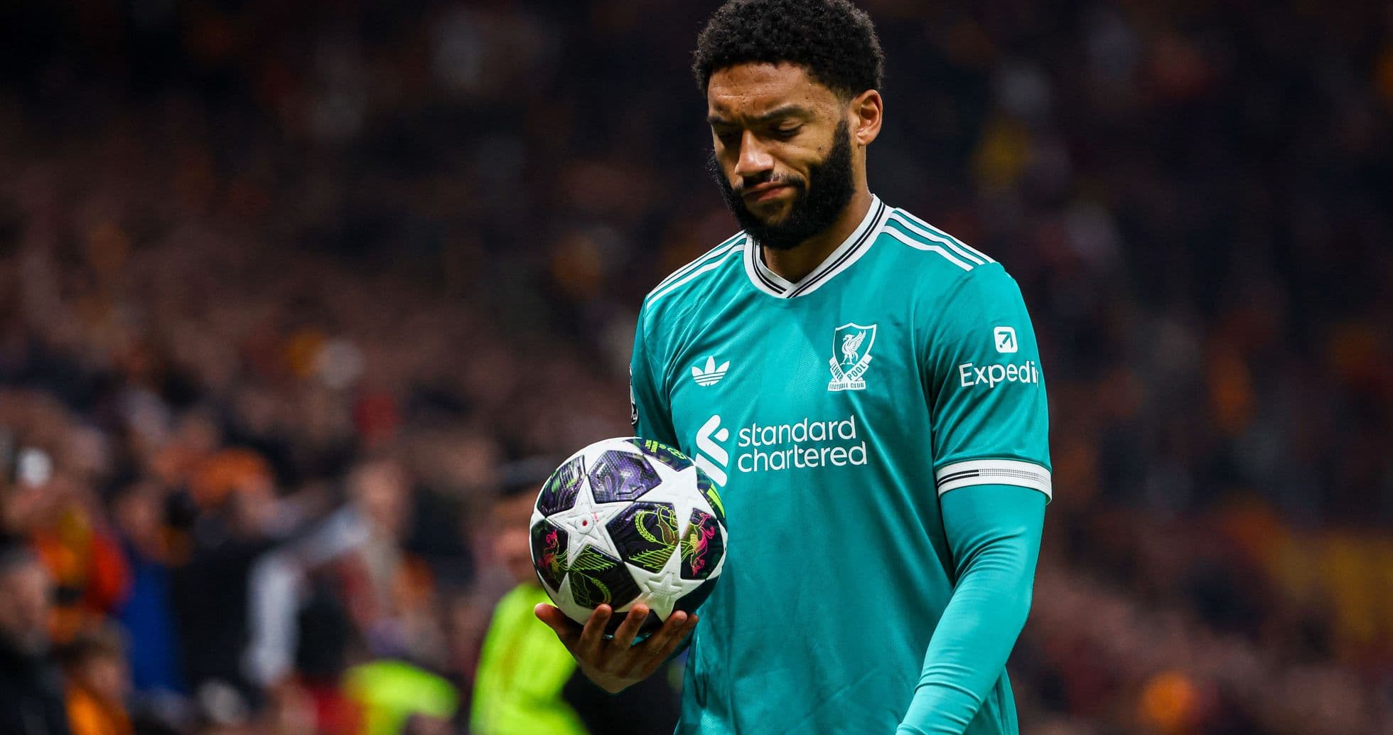Player in Liverpool kit holding a football