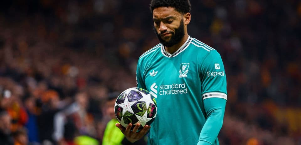 Player in Liverpool kit holding a football