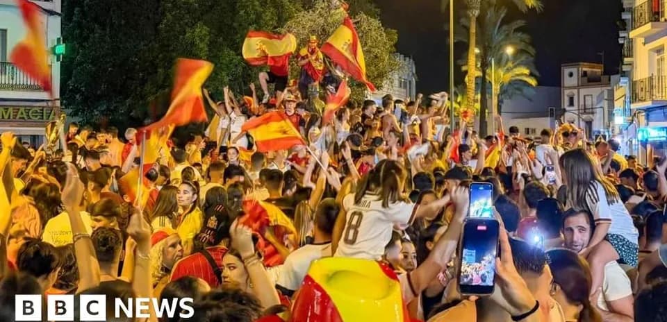 Crowd celebrating with flags in the street