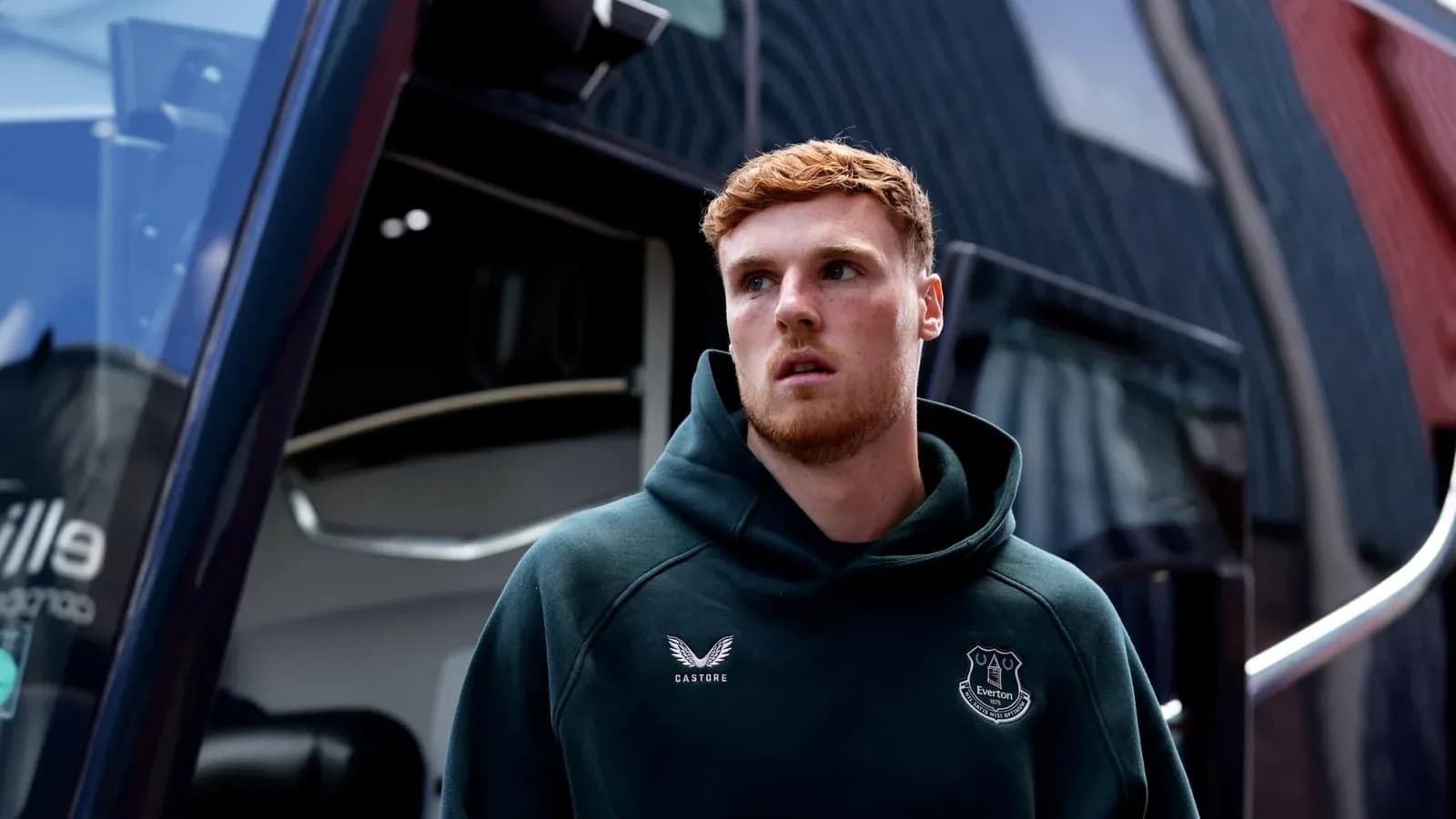 Player in Everton hoodie near team bus