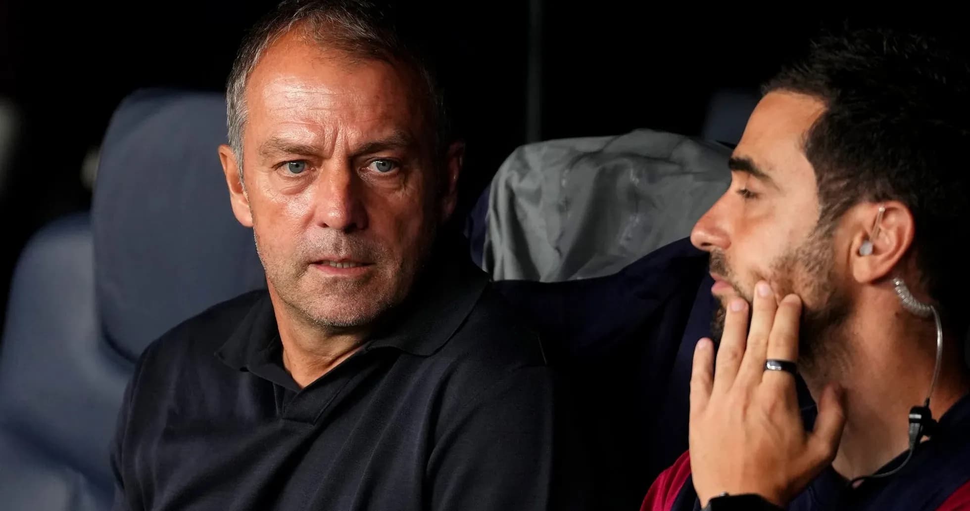 Two coaches discussing on the bench during match
