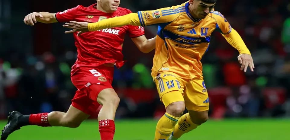 Toluca player challenging Tigres UANL player for ball
