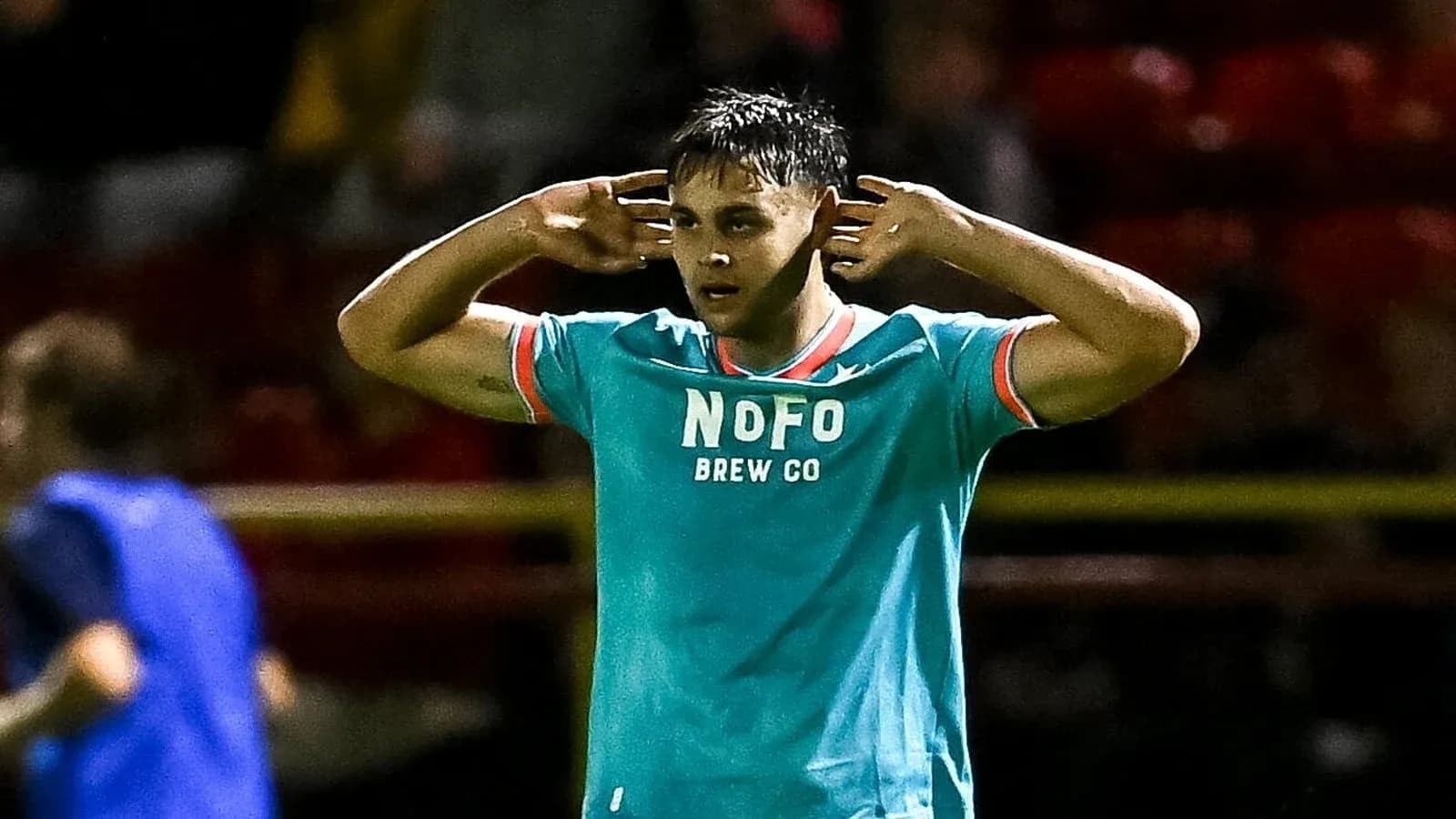 Player celebrating with hands on ears during match