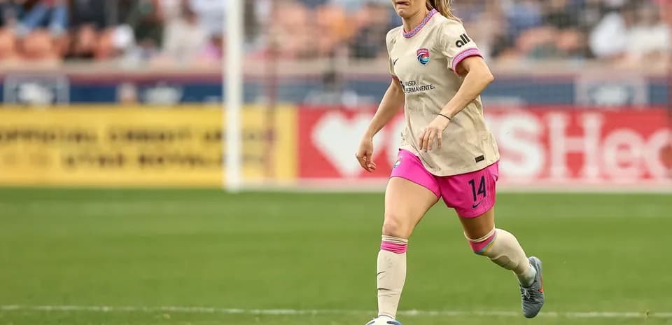 Houston Dash player dribbling the ball on field