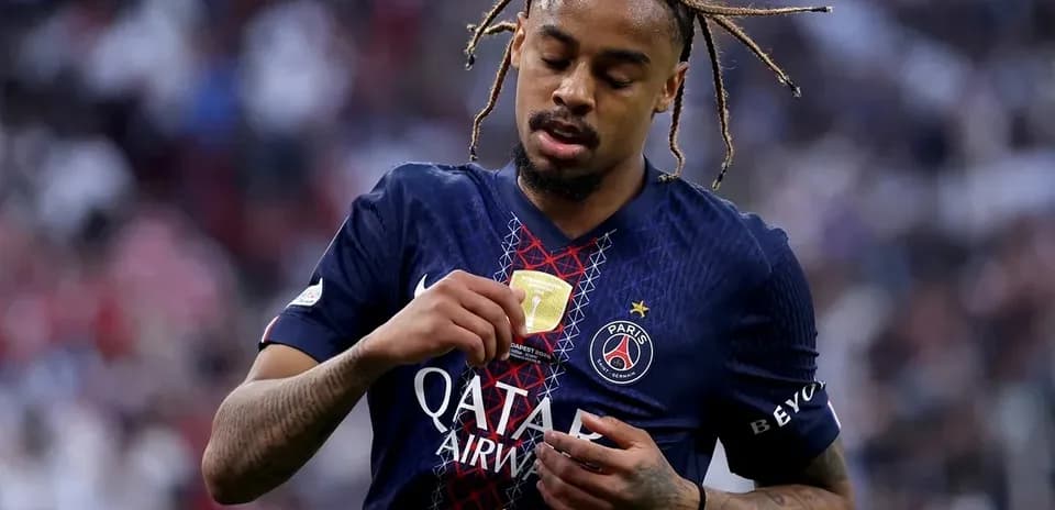 Player adjusting badge on PSG jersey during match