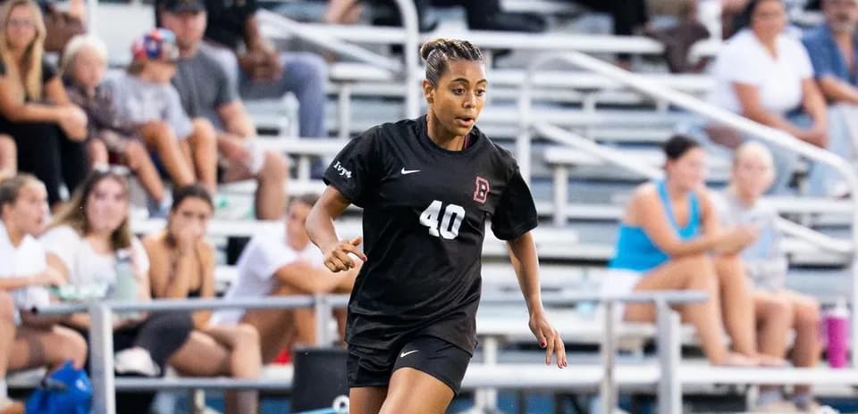 Player wearing black uniform running on soccer field