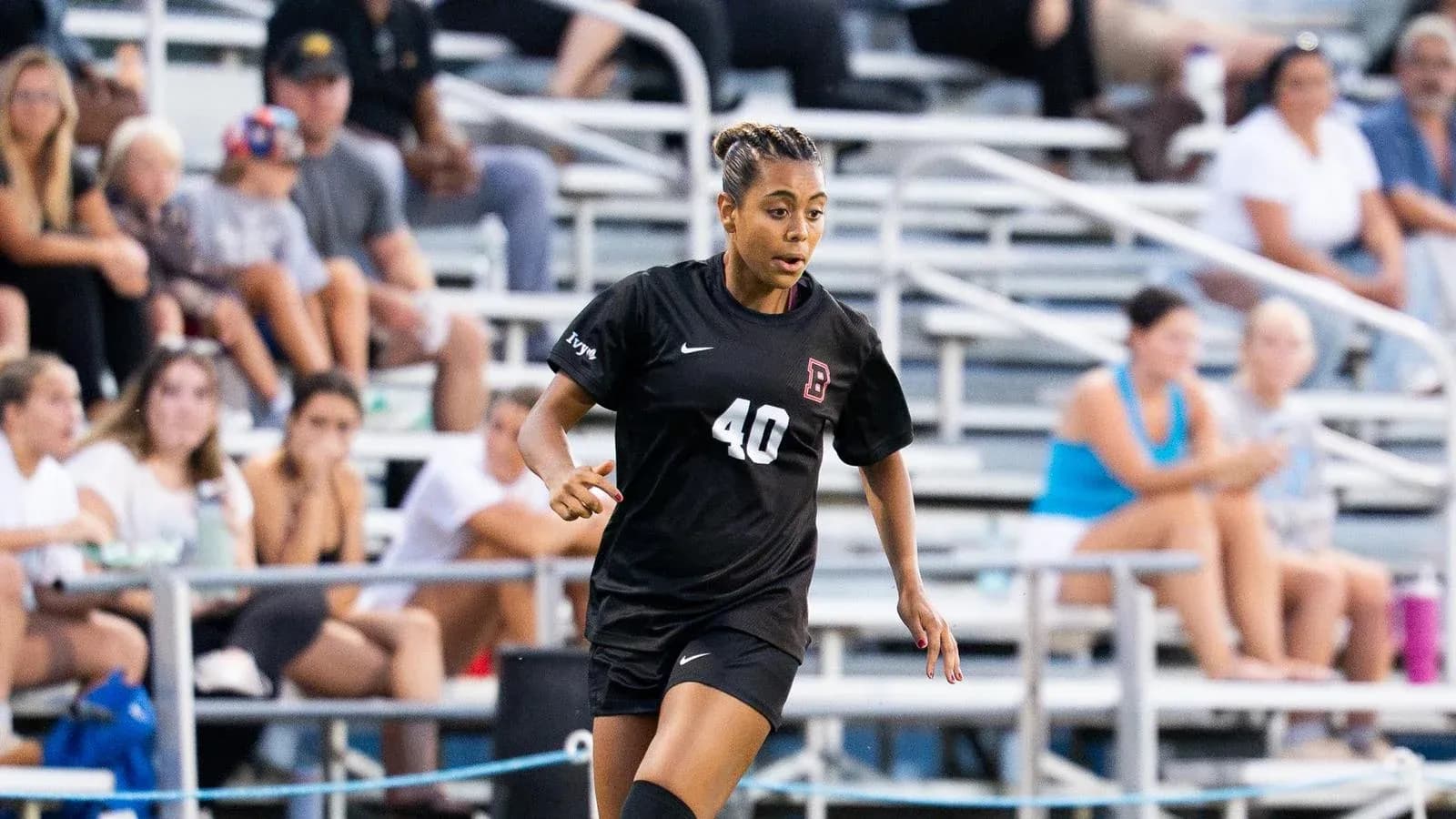 Player wearing black uniform running on soccer field
