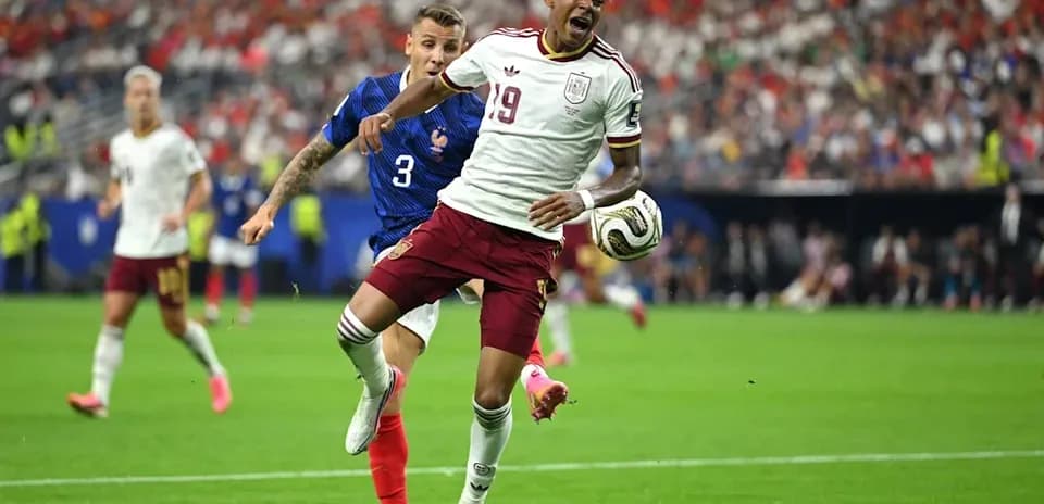 Spanish player dribbling past French defender during match