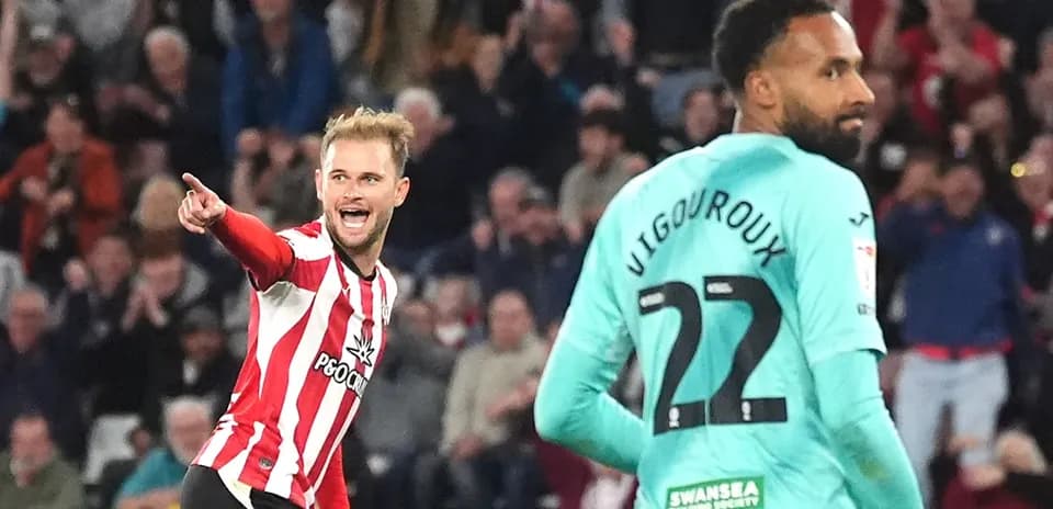 Player celebrating a goal with fans in background
