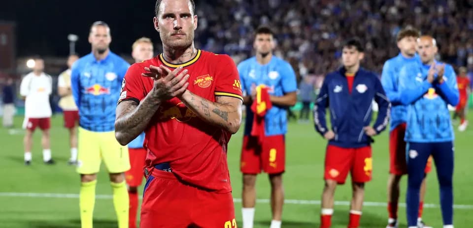 Player in red jersey applauding with teammates behind