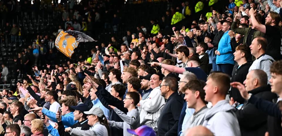 Fans cheering enthusiastically in stadium stands