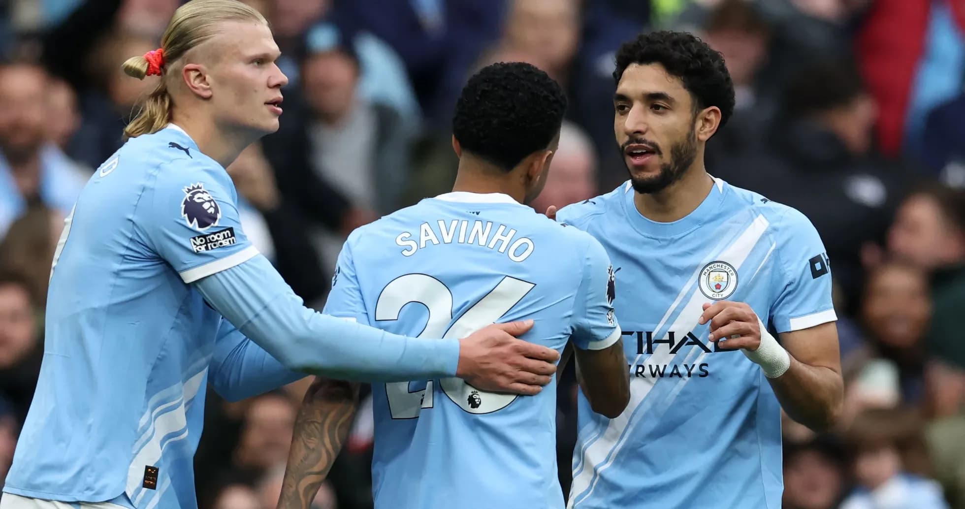 Three Manchester City players celebrating a goal