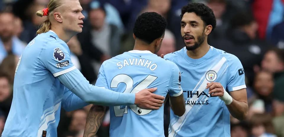 Three Manchester City players celebrating a goal
