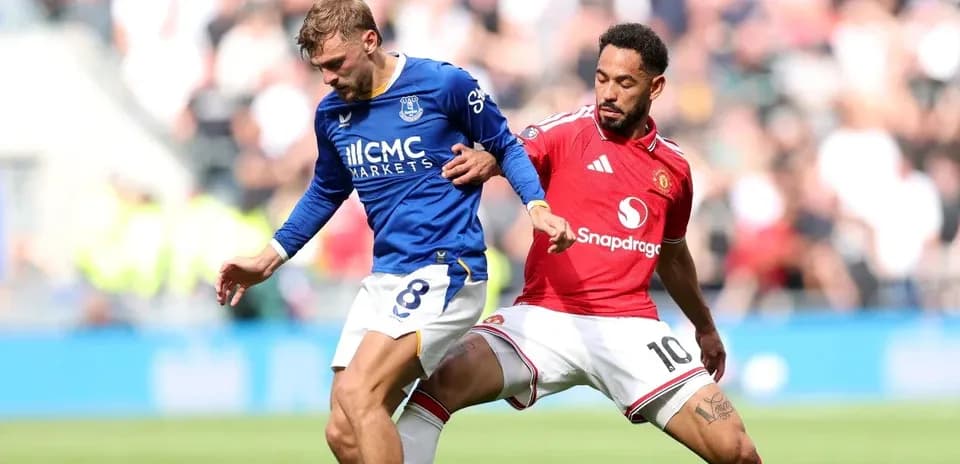 Everton player tackled by Manchester United player