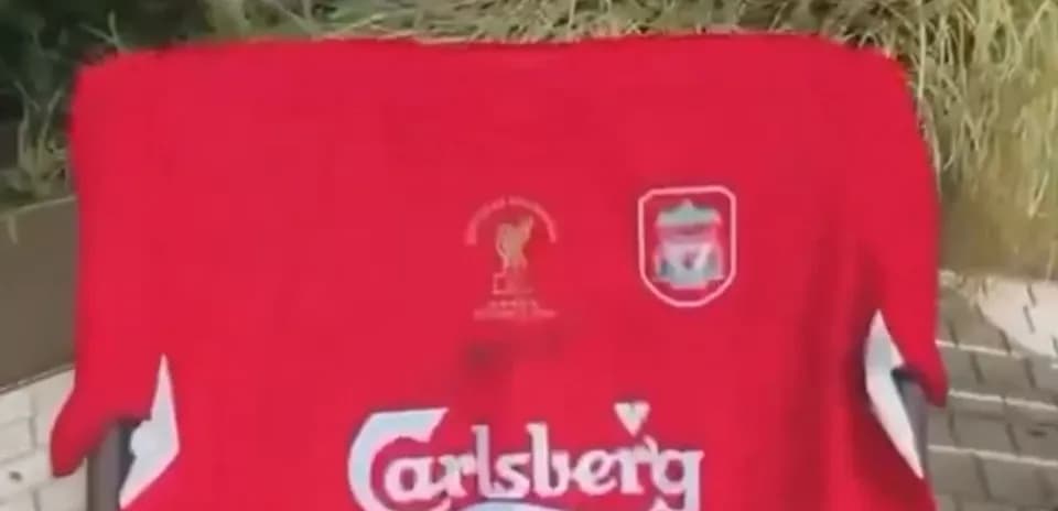 Red Liverpool jersey displayed on a surface