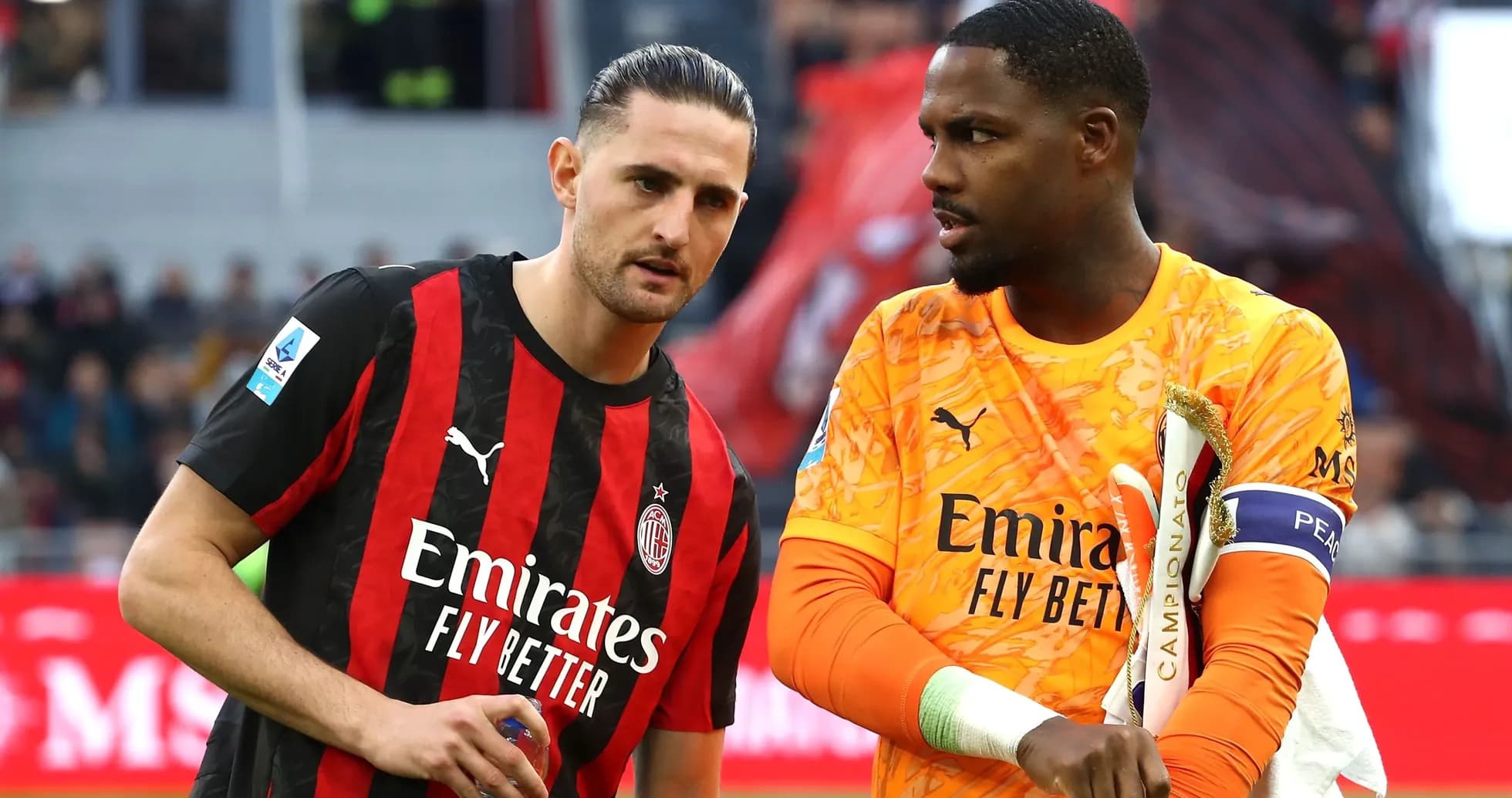 Two AC Milan players discussing on the pitch