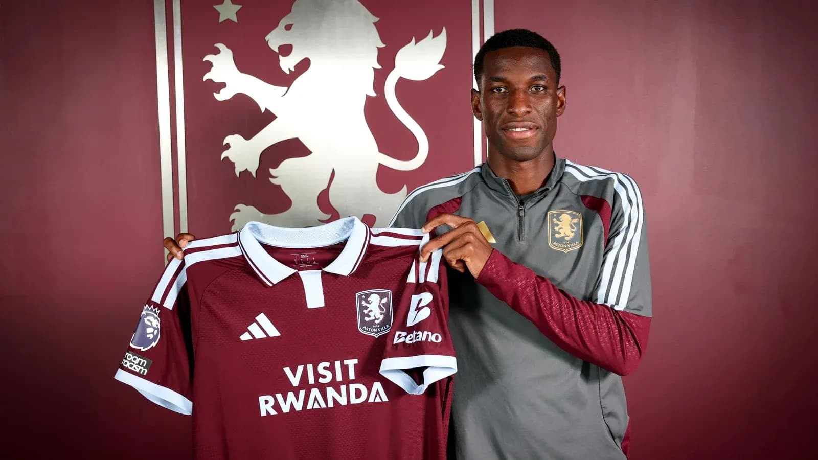 Player holding Aston Villa jersey at press event