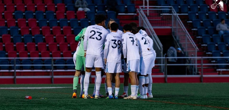 New York City II players huddling together