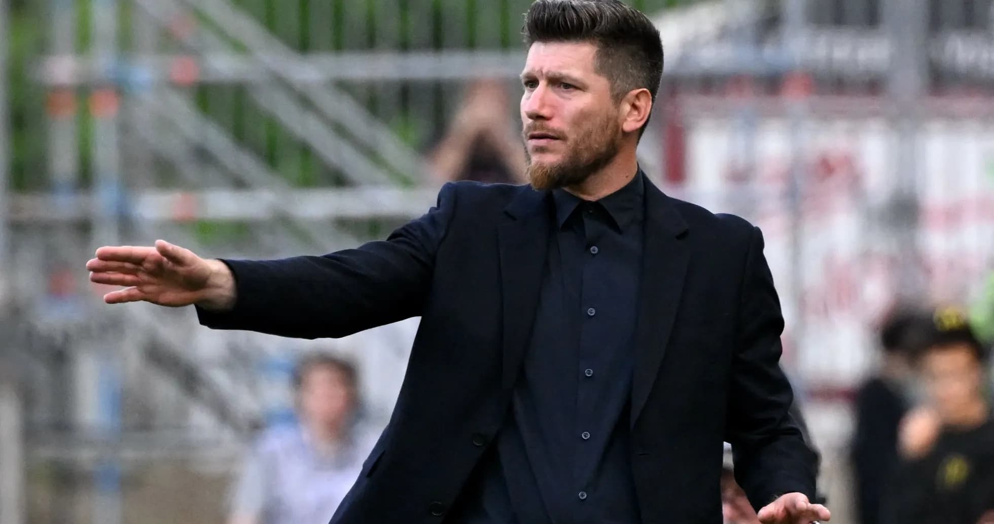 Coach gesturing during a football match on the sideline