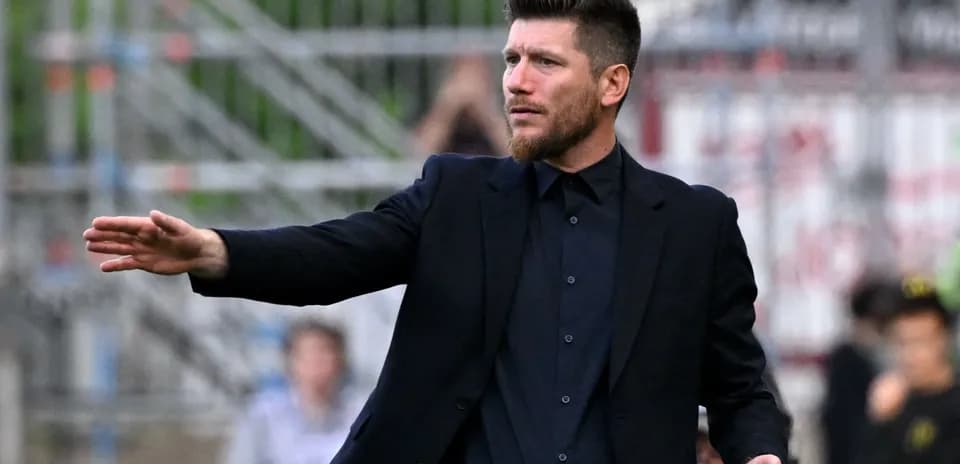 Coach gesturing during a football match on the sideline