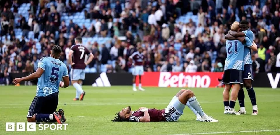 Players reacting after match, one lying on the ground