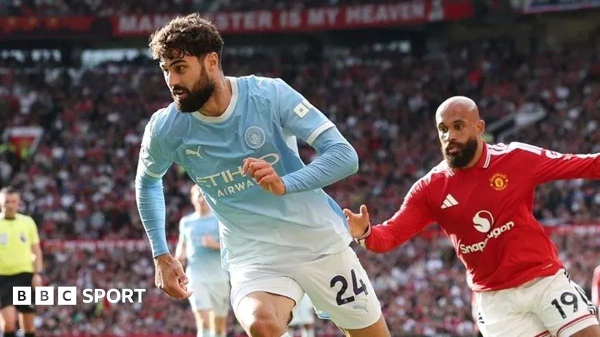 Manchester City player running past Manchester United opponent