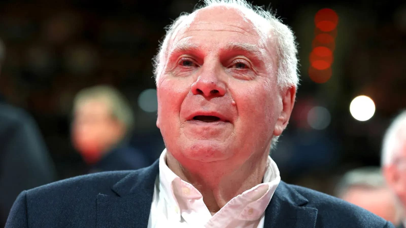 Older man in a suit at a sports event