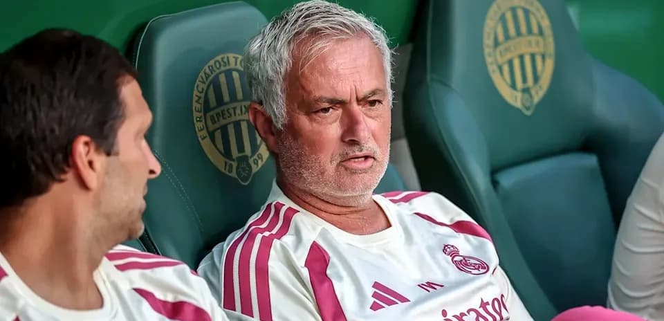 Coach and player sitting on bench during match