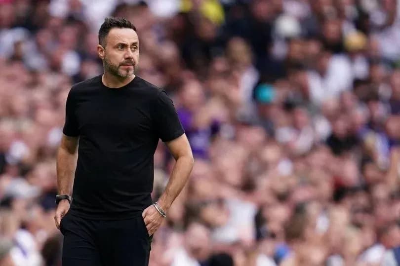 Coach walking along the sideline during match