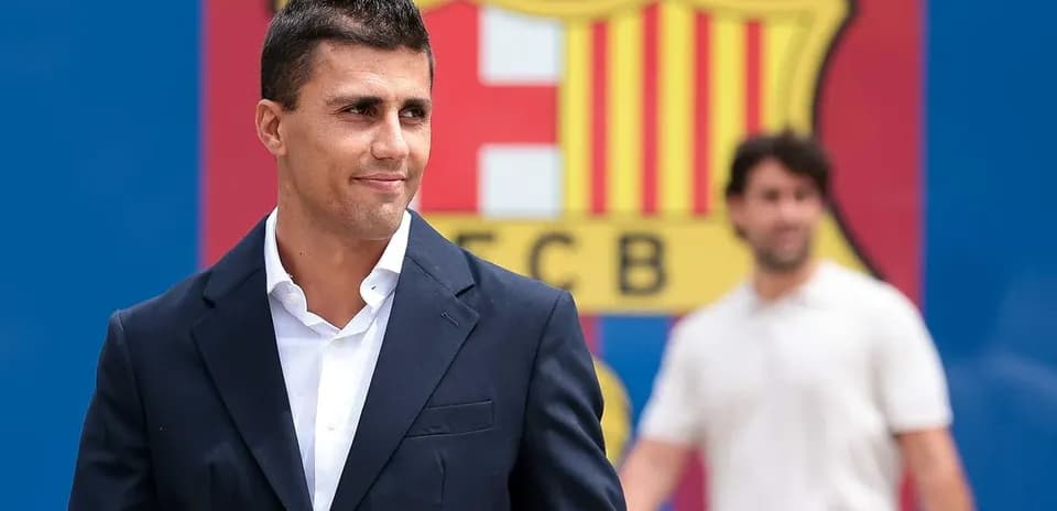 Player in suit in front of FC Barcelona logo