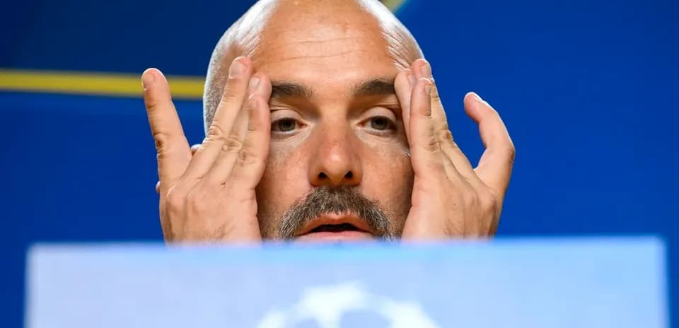 Manager at press conference touching his face