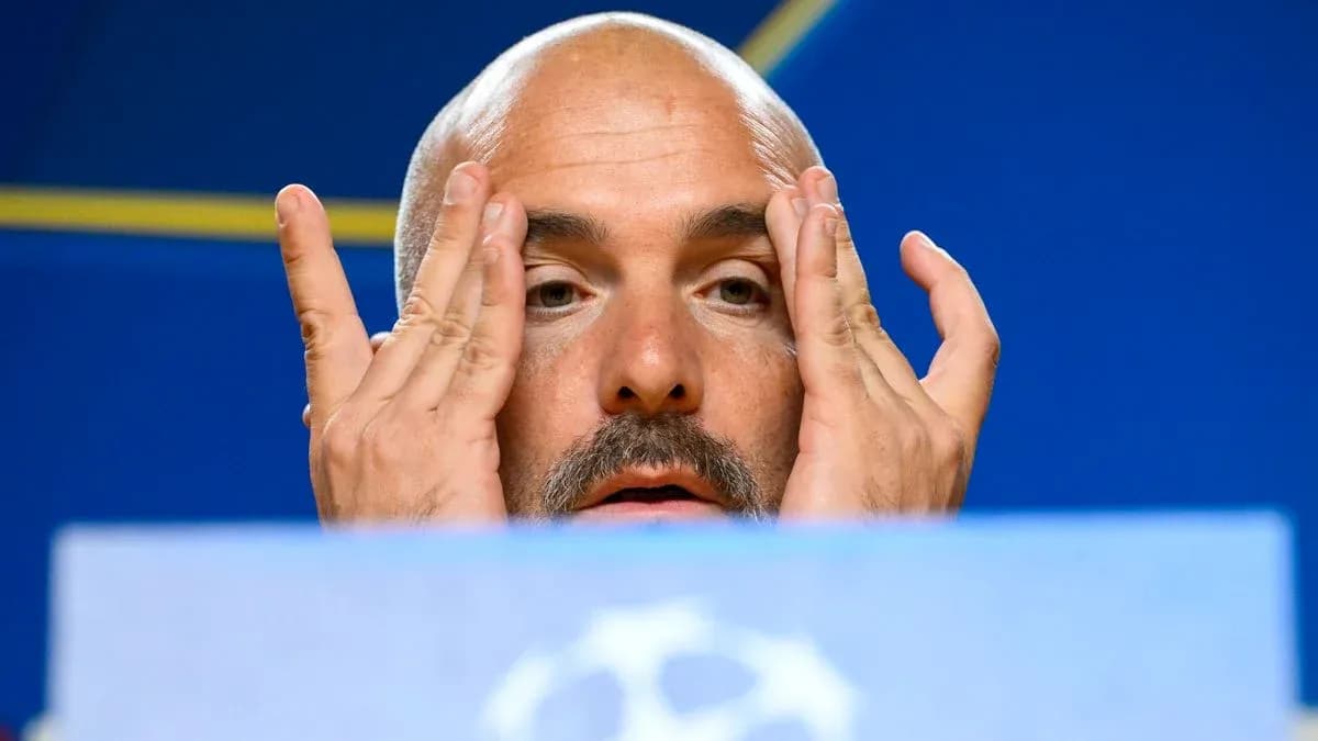 Manager at press conference touching his face