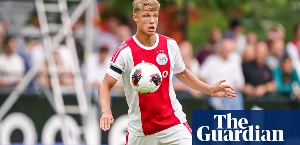 Player in Ajax kit controlling the ball on field