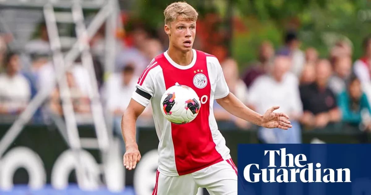 Player in Ajax kit controlling the ball on field