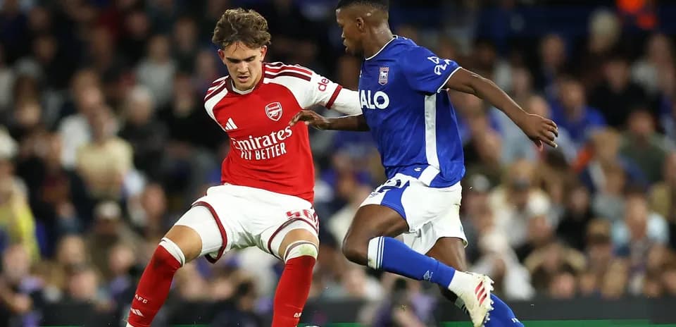 Player in red and player in blue competing for the ball
