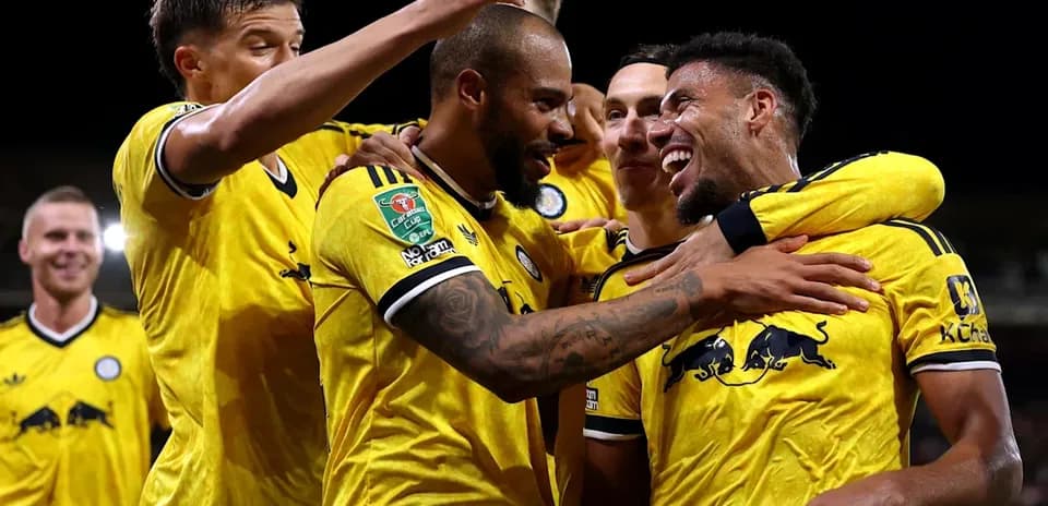 Players celebrating a goal in yellow team jerseys