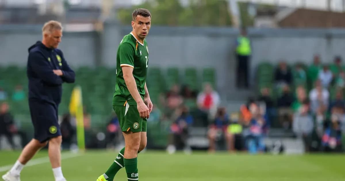 Player in green jersey during match with coach nearby