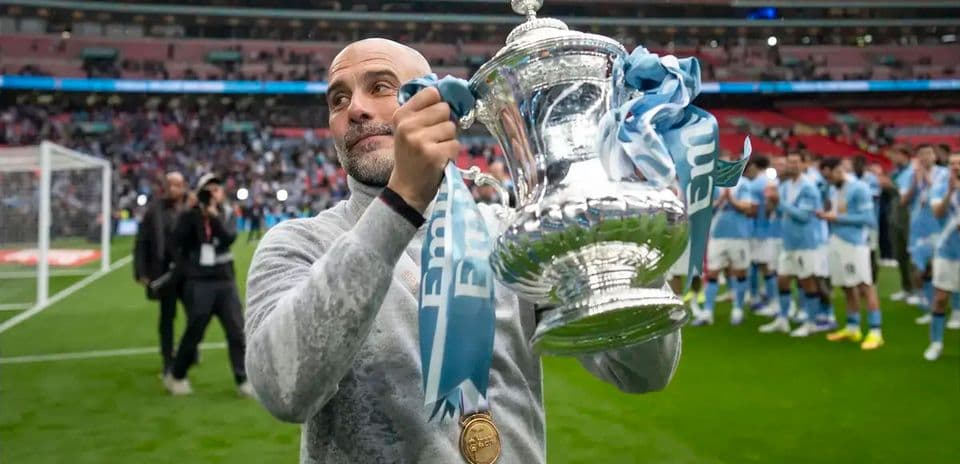 Manager holding FA Cup trophy at Wembley Stadium