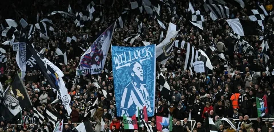 Crowd waving flags at football match