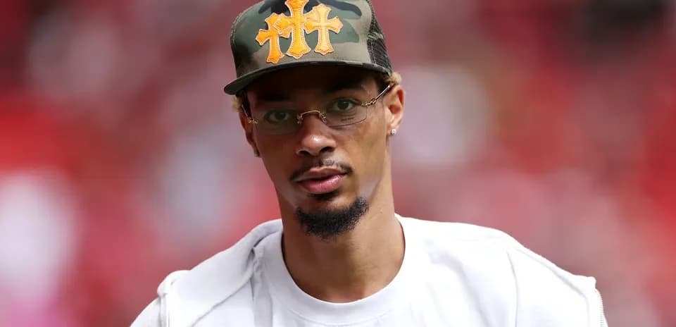 Person wearing a cap and glasses at event