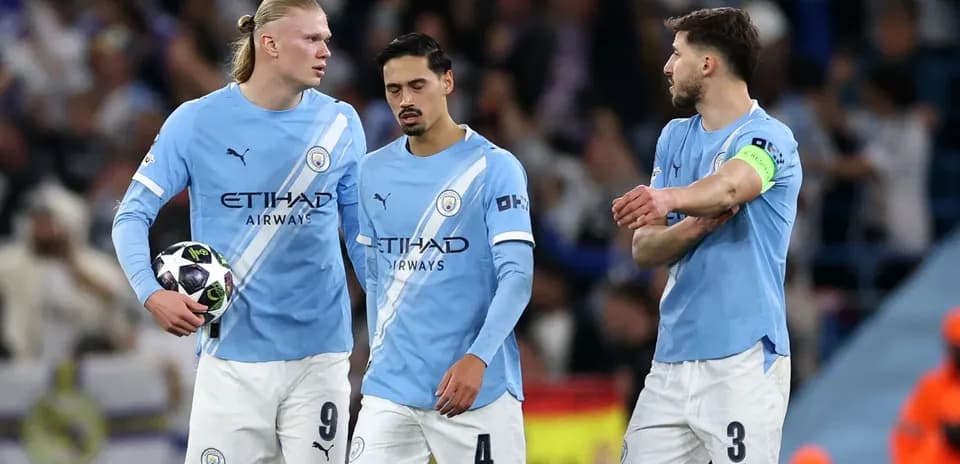 Three Manchester City players discussing on the pitch