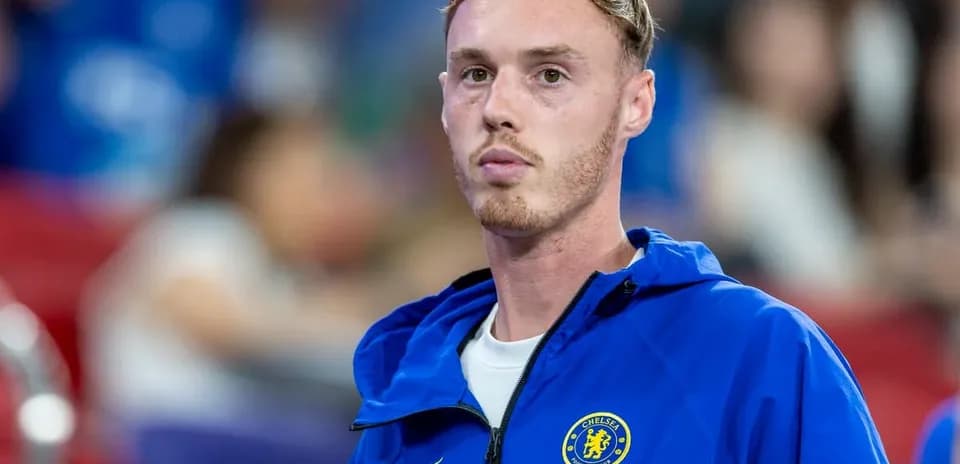 Chelsea player in blue training jacket on sidelines